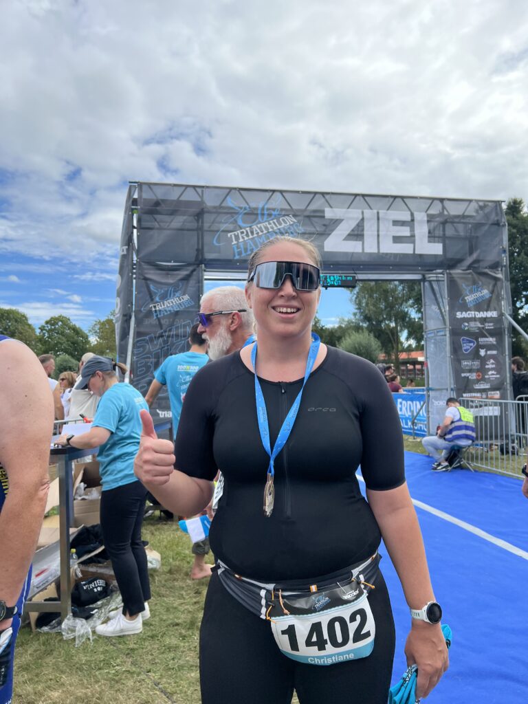 Ich im Ziel, mit Medaille um und Daumen hoch.
